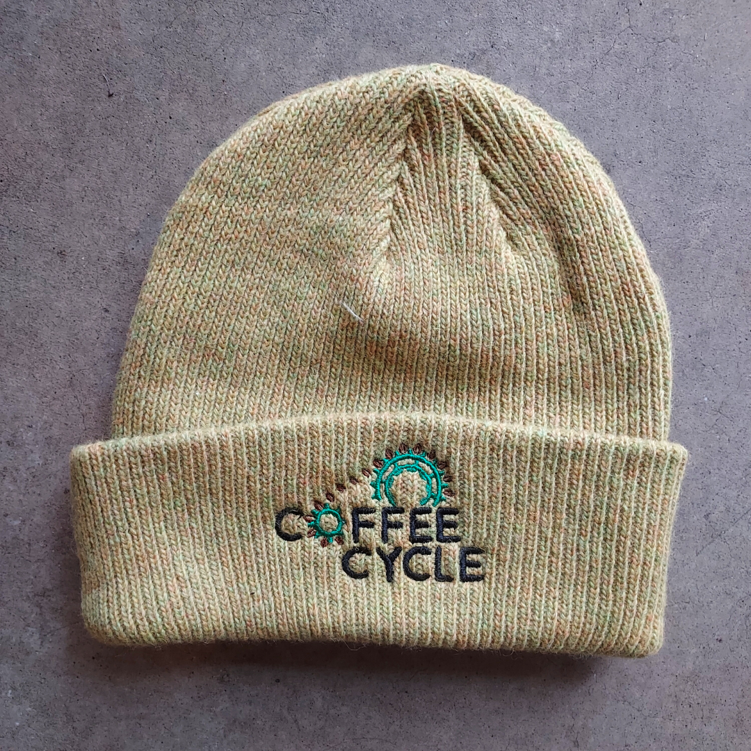 Mustard colored Merino wool beanie with the Coffee Cycle Logo embroidered in the front.