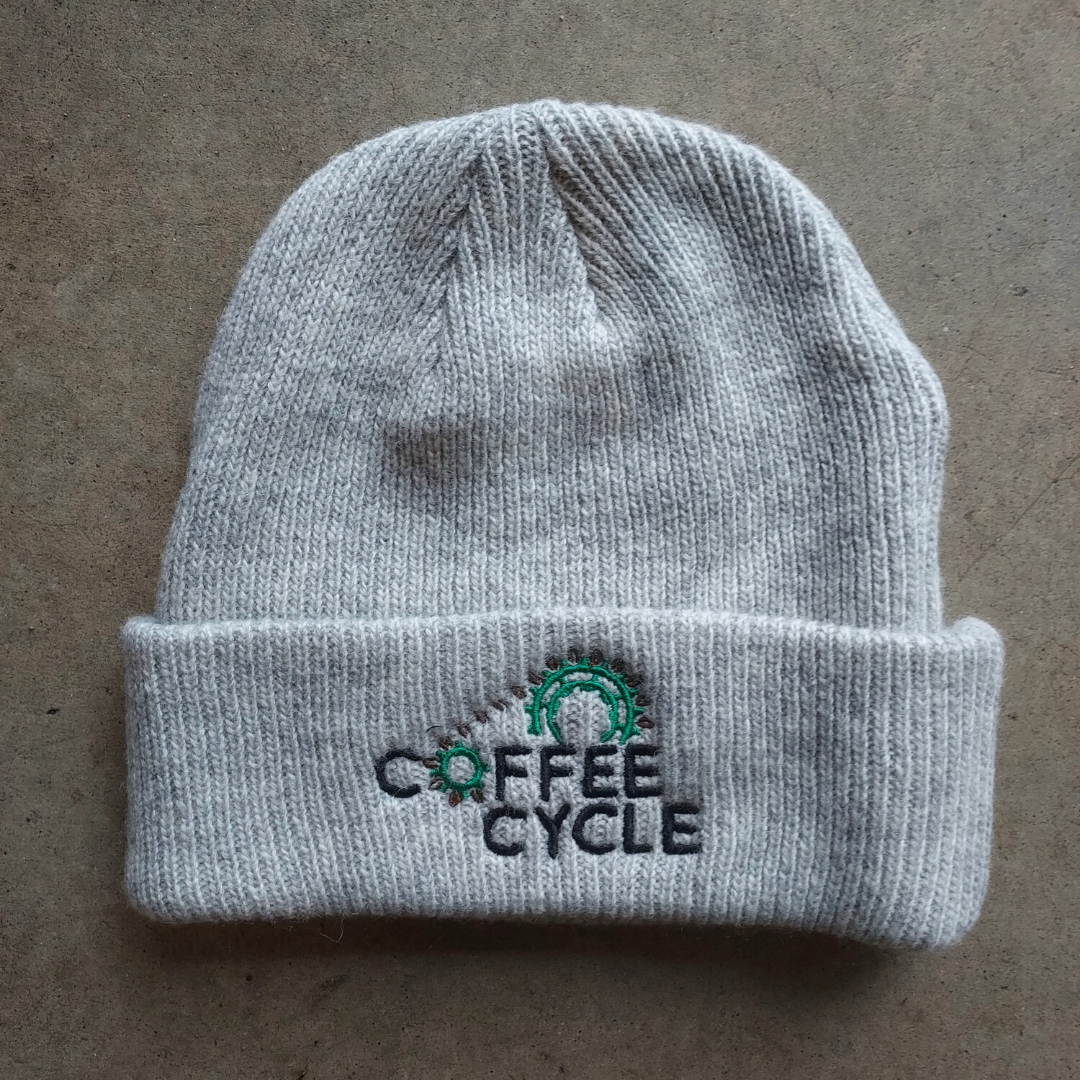 Grey colored Merino wool beanie with the Coffee Cycle Logo embroidered in the front.
